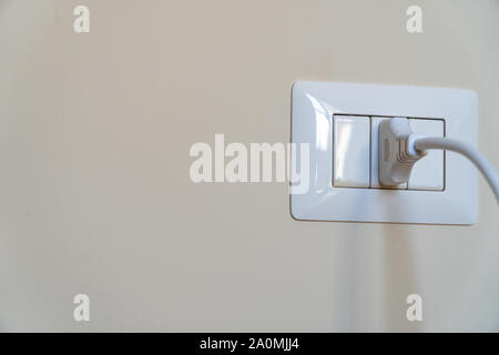 Weiße Kabel angeschlossen in einem italienischen weißen Steckdose an der Wand montiert Stockfoto