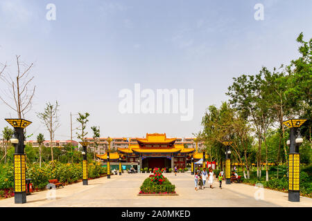 Hotan malerischen Kunlun Lake Park zurück Blick auf Main Gate Eingang mit wenige Leute an einem bewölkten Himmel Tag Stockfoto