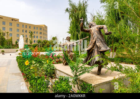 Hotan malerischen Kunlun See mit Blick auf den Park der Uigurischen Tanzpaare Statue an einem bewölkten Himmel Tag Stockfoto