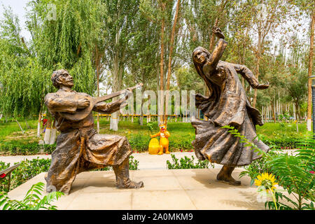 Hotan malerischen Kunlun See mit Blick auf den Park der Uigurischen Tanzpaare Statue an einem bewölkten Himmel Tag Stockfoto