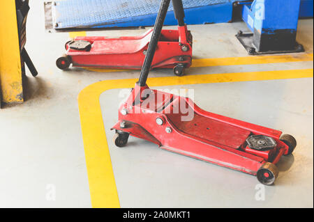 Hydraulikzylinder für Auto anheben und das Fahrzeug in Reparatur Garage Werkstatt Service Center. Werkzeug und Ausrüstung von Kfz-Konzept. Stockfoto