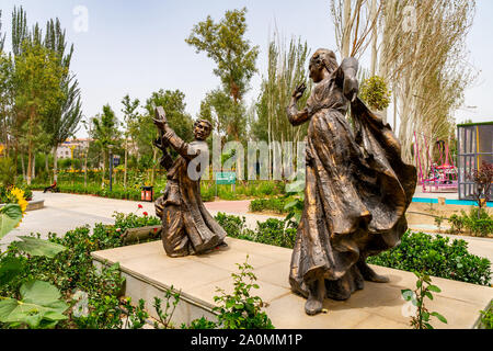 Hotan malerischen Kunlun See mit Blick auf den Park der Uigurischen Tanzpaare Statue an einem bewölkten Himmel Tag Stockfoto