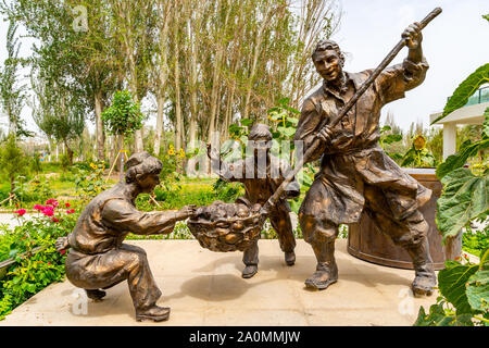 Hotan malerischen Kunlun Lake Park der Uigurischen Vater und zwei Söhne Kochen Statue an einem bewölkten Himmel Tag Stockfoto