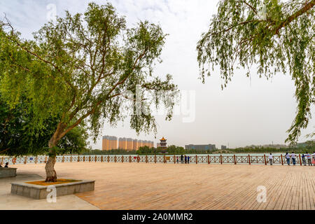 Hotan malerischen Kunlun Park riesigen hölzernen Terrasse mit atemberaubenden Blick auf den See an einem bewölkten Himmel Tag Stockfoto