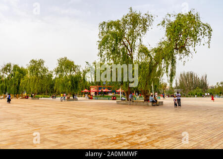 Hotan malerischen Kunlun Lake Park Blick auf riesigen hölzernen Terrasse mit wenige Leute an einem bewölkten Himmel Tag Stockfoto