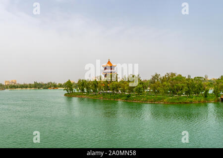 Hotan malerischen Kunlun Lake Park Blick auf eine atemberaubende Pagode auf einer Insel an einem bewölkten Himmel Tag Stockfoto