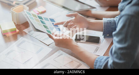7/8-Ansicht von UI-Designer Hobeln der UX-Anwendungsentwicklung mit Teammitgliedern Stockfoto