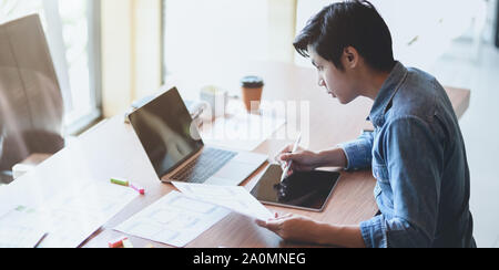 7/8-Ansicht von UX Web Developer zeichnen das Smartphone Vorlagen auf Tablet in modernen Büro Zimmer Stockfoto