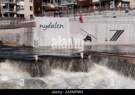 Oslo, Norwegen - 11 April 2010: Norwegische Jugendliche sprechen unter der Sonne Feiern der Frühling kommt. Nydalen, Fluss Akerselva Stockfoto