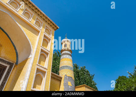 Kashgar Id kah-Moschee Low Angle View des Gelben farbigen Fliesen Minarett auf einem sonnigen blauen Himmel Tag Stockfoto