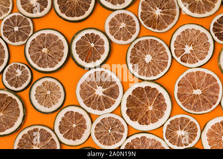 Getrocknete Scheiben von Kalk bei orange Hintergrund Stockfoto