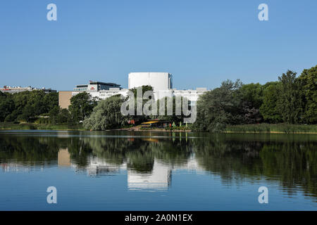 Oopperatalo oder das Opernhaus (die Finnische Nationaloper und das Ballett) an einem sonnigen Sommermorgen in Helsinki, Finnland, über der ruhigen Töölönlahti-Bucht Stockfoto