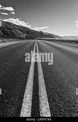 Blick auf eine endlose gerade Straße durch die Wüste in den USA läuft Stockfoto