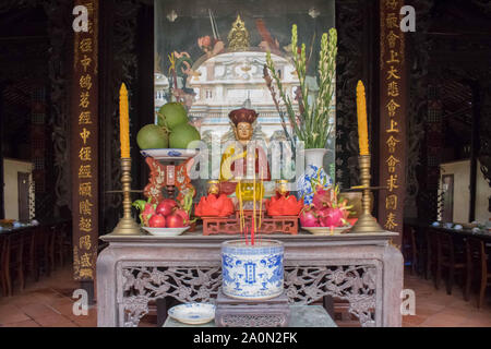 Juli 18, 2019 - My Tho, VIETNAM: Beleuchtete Weihrauch am Altar auf einem buddhistischen Tempel in Vietnam. Vihn Trang Pagode in Vietnam. Die Früchte sind bei den Angeboten Stockfoto