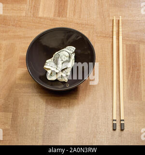US-Dollar-Schein in einer Schüssel, Teller, mit chinesischen Essstäbchen – USA China Handelskonzept Stockfoto