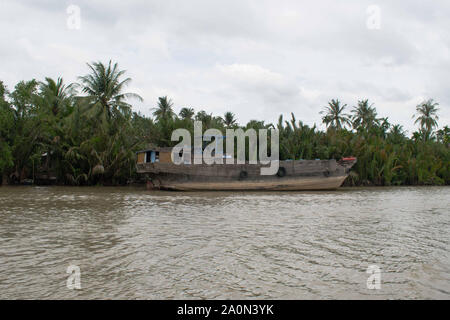 Juli 18, 2019 - MEKONG DELTA, VIETNAM: großen hölzernen Boot entlang der Ufer des Flusses Mekong Delta in Vietnam geparkt Stockfoto