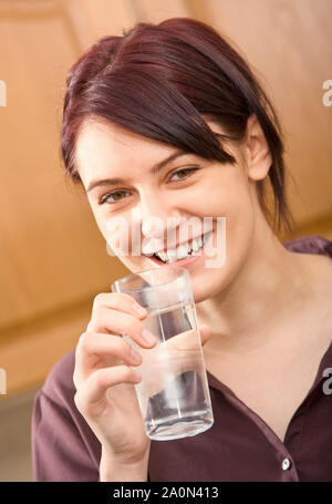 Junge Frau trinkt ein Glas Wasser Stockfoto