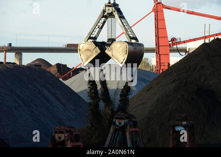 Deutschland, Hamburg, Hansaport Import von Kohle und Erz, Entladen von Steinkohle mit grossen Bagger Schaufel/Deutschland, Hamburg, Hansaport, Import von Kohle und Erz, Lagerung und Weitertransport zu Kraftwerken und Stahlwerken Stockfoto