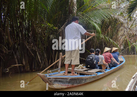 Juli 18, 2019 - MEKONG DELTA, VIETNAM: Vietnam lokale Paddeln ein Boot, die Touristen entlang des Mekong Delta Fluss/Kanal. Stockfoto