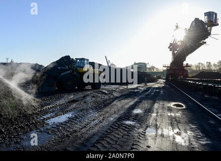 Deutschland, Hamburg, Hansaport Import von Kohle und Erz für Stahlwerke und Kohlekraftwerke, Kohle Abstellraum, großes Schaufelrad Bagger gegen die Sonne/Deutschland, Hamburg, Hansaport, Import von Kohle und Erz, Lagerung und Weitertransport zu Kraftwerken und Stahlwerken Stockfoto