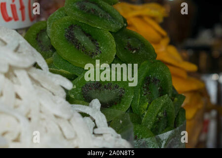 Getrocknete Früchte wie Kokosnuss, grüne Kiwi und Mango auf Anzeige auf einem Markt in Vietnam Stockfoto