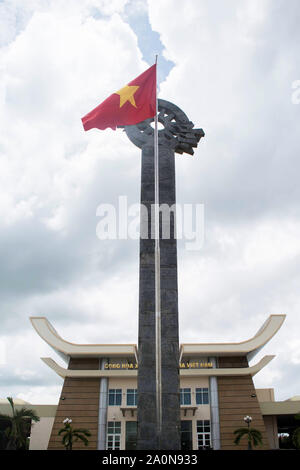 Juli 19, 2019 - ca. VIETNAM: Vietnam Fahne in der Nähe des hohen geschnitzten Monument an der Grenze von Vietnam und Kambodscha. Stockfoto