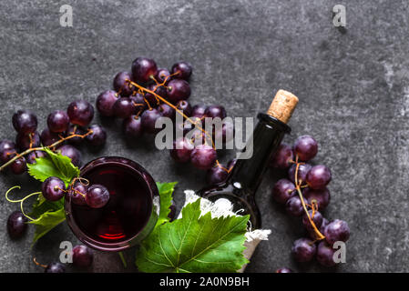 Wein aus Weintrauben Hintergrund. Rotwein Glas und Flasche mit Korken. Stockfoto