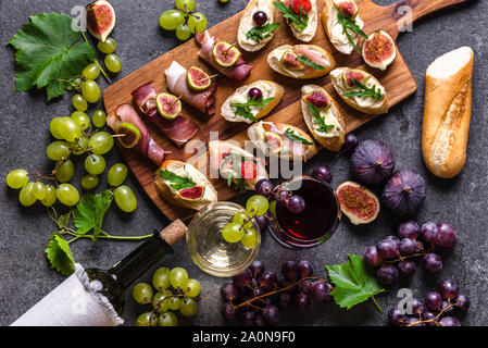 Traditionelle spanische Tapas, Wein snack Set - Lebensmittel aus Spanien oder italienische Antipasti: Bruschetta mit Käse, Fleisch und Obst. Kalte Vorspeisen und Wein gl Stockfoto