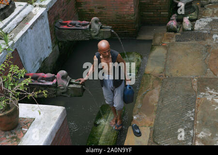 KATHMANDU, Nepal. 23. September 2008: ein Mann nimmt das Wasser aus der öffentlichen Wasserleitung auf der Straße Stockfoto