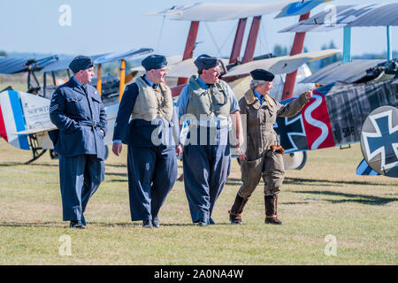 Duxford, England. 21. Sep 2019. Re-enactors in Periode RAF Kostüm pass WW1 bi-Flugzeuge - Duxford die Schlacht um England Air Show im Imperial War Museum. Auch zum Gedenken an den 50. Jahrestag der Schlacht von Großbritannien 1969 Film. Es läuft am Samstag, 21. und Sonntag, 22. September 2019 Credit: Guy Bell/Alamy leben Nachrichten Stockfoto