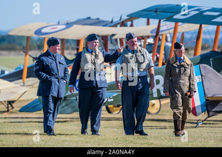 Duxford, England. 21. Sep 2019. Re-enactors in Periode RAF Kostüm pass WW1 bi-Flugzeuge - Duxford die Schlacht um England Air Show im Imperial War Museum. Auch zum Gedenken an den 50. Jahrestag der Schlacht von Großbritannien 1969 Film. Es läuft am Samstag, 21. und Sonntag, 22. September 2019 Credit: Guy Bell/Alamy leben Nachrichten Stockfoto