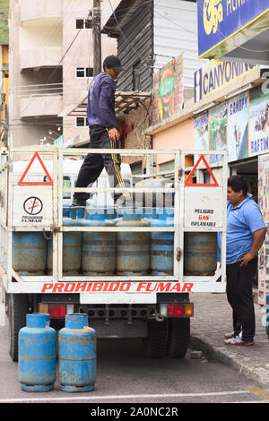 BANOS, Ecuador - 28. FEBRUAR 2014: Nicht identifizierte Personen auf einen Lkw voll Gas Flaschen auf der 16 de November Straße in Baños, Ecuador Stockfoto