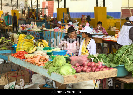 BANOS, Ecuador - 26. FEBRUAR 2014: Unbekannter Frauen sprechen auf dem Markt am Plaza 5 de Oct am 26. Februar 2014 in Banos, Ecuador. Stockfoto