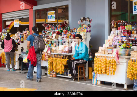 BANOS, ECUADOR - 7. MÄRZ 2014: Unbekannter junger Mann an einen Snack im Bus Terminal am 7. März 2014 in Banos, Ecuador Stockfoto