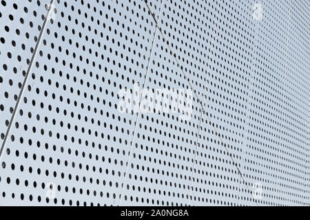 Blick diagonal von metall gitter und runde Löcher in metallenen Oberfläche, perforierte Panels zur Kulisse. Stockfoto