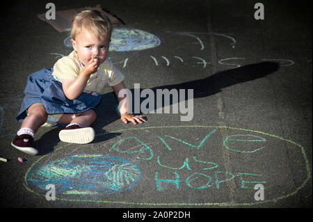 Glasgow, UK. 20. September 2019. Im Bild: Ein Kind sitzt auf dem Boden vor einer Zeichnung eines Globus mit einem Slogan 'Hoffnung'. Wird es etwas für unsere zukünftige Generationen hinterlassen werden? Szenen aus einem geplanten Protest auf dem George Square am Nachmittag nach Streiks begann vor einem Jahr die 16-jährige Schwedische Schulmädchen namens Greta Thunberg. Hunderte von Kreide markiert Slogans der Beton der George Square mit Demonstranten aus allen Alters und aller Hintergründe übersät. Stockfoto