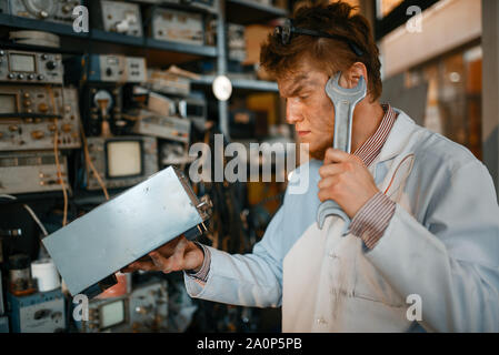 Seltsame Wissenschaftler mit elektrischen Gerät und Schraubenschlüssel Stockfoto