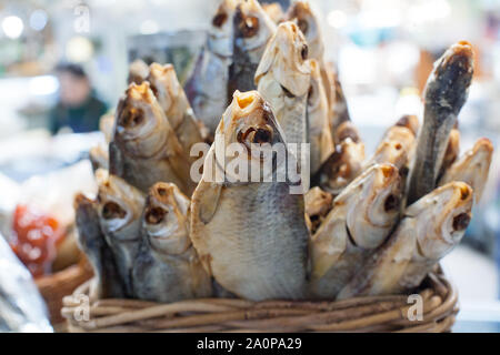 Getrocknet gesalzen barsch Fisch im Korb close up, chemische Seebarsch Verkauf auf Seafood Market, lecker Stockfisch, ruckartige Schwadleger, salzig gekocht Sunfish, salzig Snapper Stockfoto