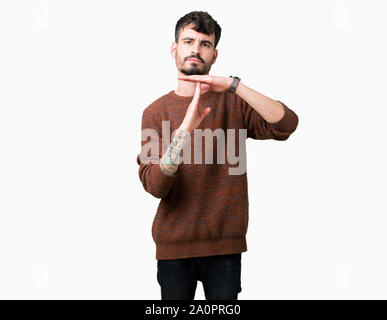 Jungen gutaussehenden Mann tragen winter Pullover über isolierte Hintergrund tun time out Geste mit den Händen, frustriert und ernstes Gesicht Stockfoto