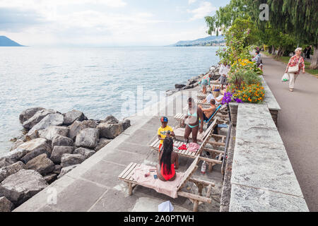 Multikulturelle Gemeinschaft genießen Sommer Wetter am Strand am Genfer See und Montreux Riviera Promenade in Clarens, Waadt, Schweiz Stockfoto