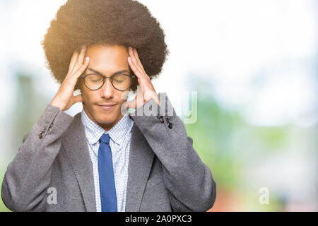 Junge afrikanische amerikanische Geschäftsmann mit afro Haar Brille mit der Hand auf den Kopf für Schmerzen im Kopf, weil Stress. Migräne leiden. Stockfoto
