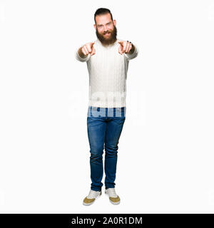 Junge hipster Mann winter Pullover, die auf sie und die Kamera mit den Fingern, Lächeln, positiven und fröhlichen Stockfoto