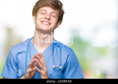 Junger Arzt mit medizinischen gleichmäßig über isolierte Hintergrund Hand, und die Finger gekreuzt Lächeln entspannt und gut gelaunt. Erfolg und optimistisch Stockfoto