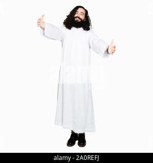 Mann, der Jesus Christus Kostüm in die Kamera lächelnd mit offenen Armen für die Hug suchen. Fröhlichen Ausdruck Glück umarmen. Stockfoto