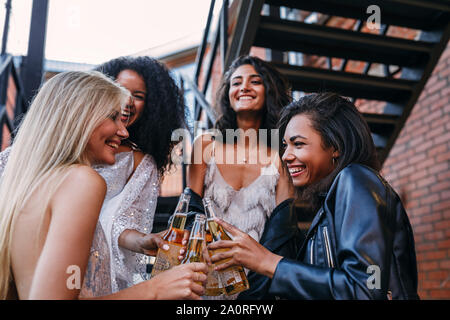 Schönen lachen Freunde Toasten mit Flaschen Bier im Freien Stockfoto