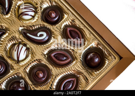 Pralinen in verschiedenen Formen in Gold, Ansicht von oben. Auf einem weißen Hintergrund. Close-up. Stockfoto