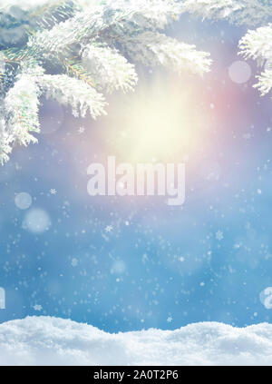 Schöne verschneite Winterlandschaft mit einem verschneiten Tannen Zweig, Schneeflocken und blauer Himmel. Winter Weihnachten Hintergrund. Winter Konzept. Stockfoto