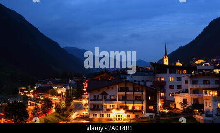 Abend Stadtbild von Ischgl, einer Stadt im Paznaun, Tirol, Österreich. Rotes Licht Wanderwege und beleuchteten Gebäuden mit starburst Wirkung. Stockfoto