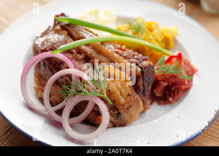 Gegrillte Rippchen mit Sauerkraut und Kartoffelpüree auf Tisch im Restaurant Stockfoto