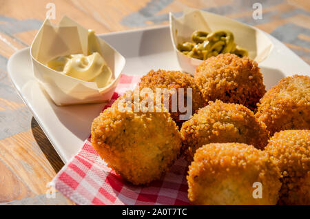 In der Nähe der Traditionellen holländischen Frikadellen (auch bekannt als bitterballen) mit Pappbechern, Mayonaise und Senf im Hintergrund auf der sonnenbeschienenen Holz- Registerkarte Stockfoto